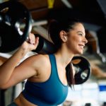Happy female athlete having strength training in a gym.