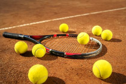 Racket and scattered tennis balls on the court